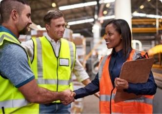 A supervisor shaking hands with a worker in a distribution center.